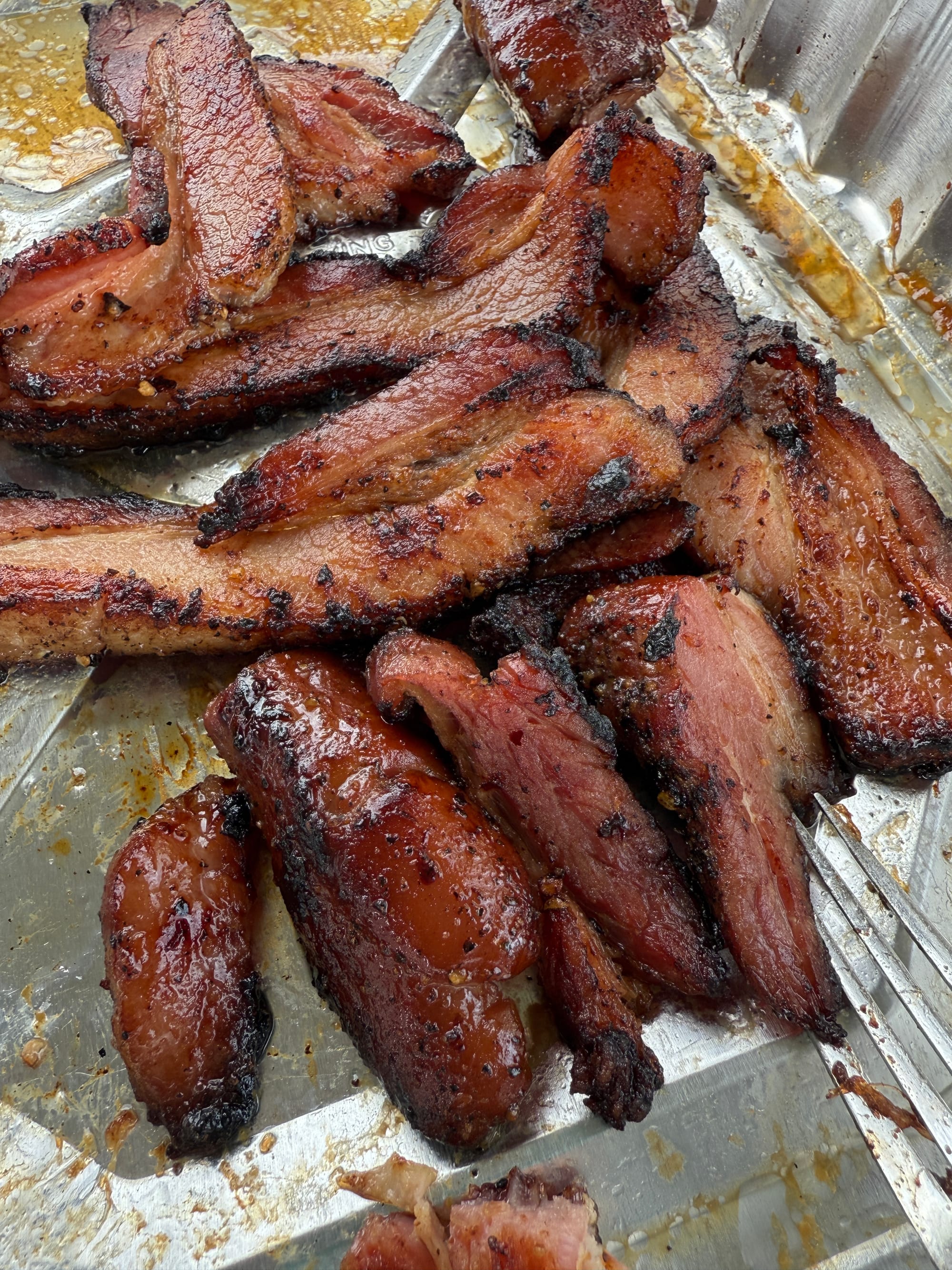Greasy, fried bacon ready to be consumed.
