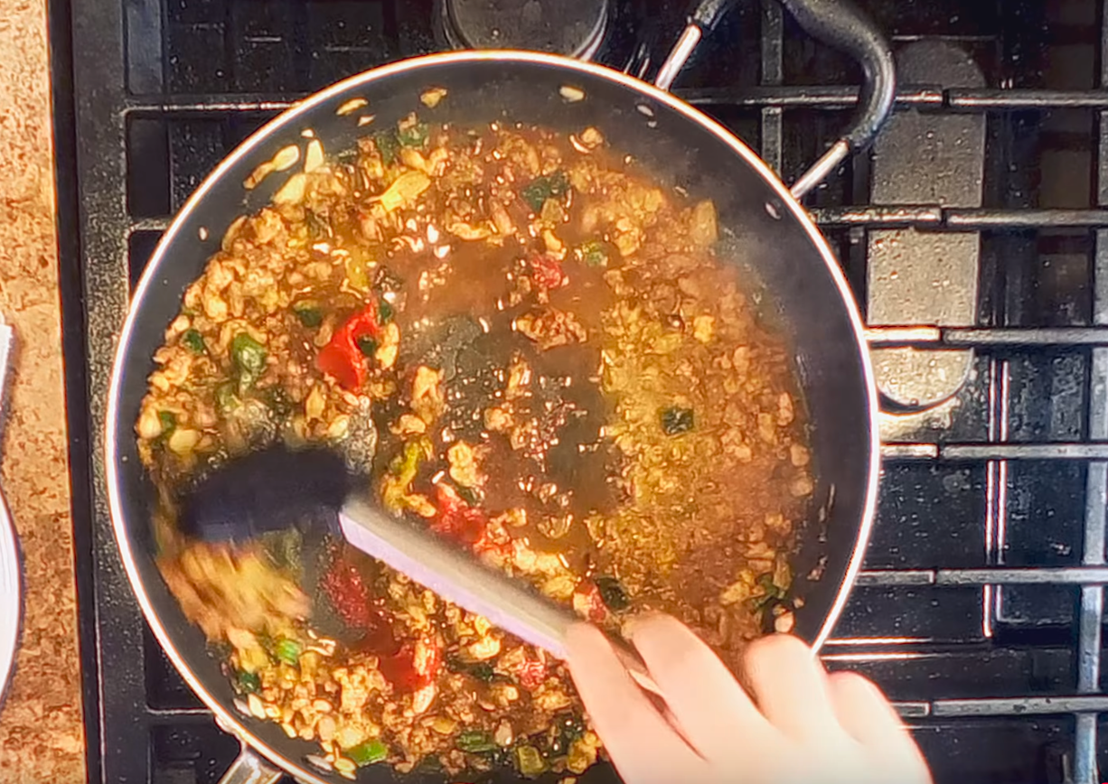 Overhead photo of Addie stirring food in a skillet.