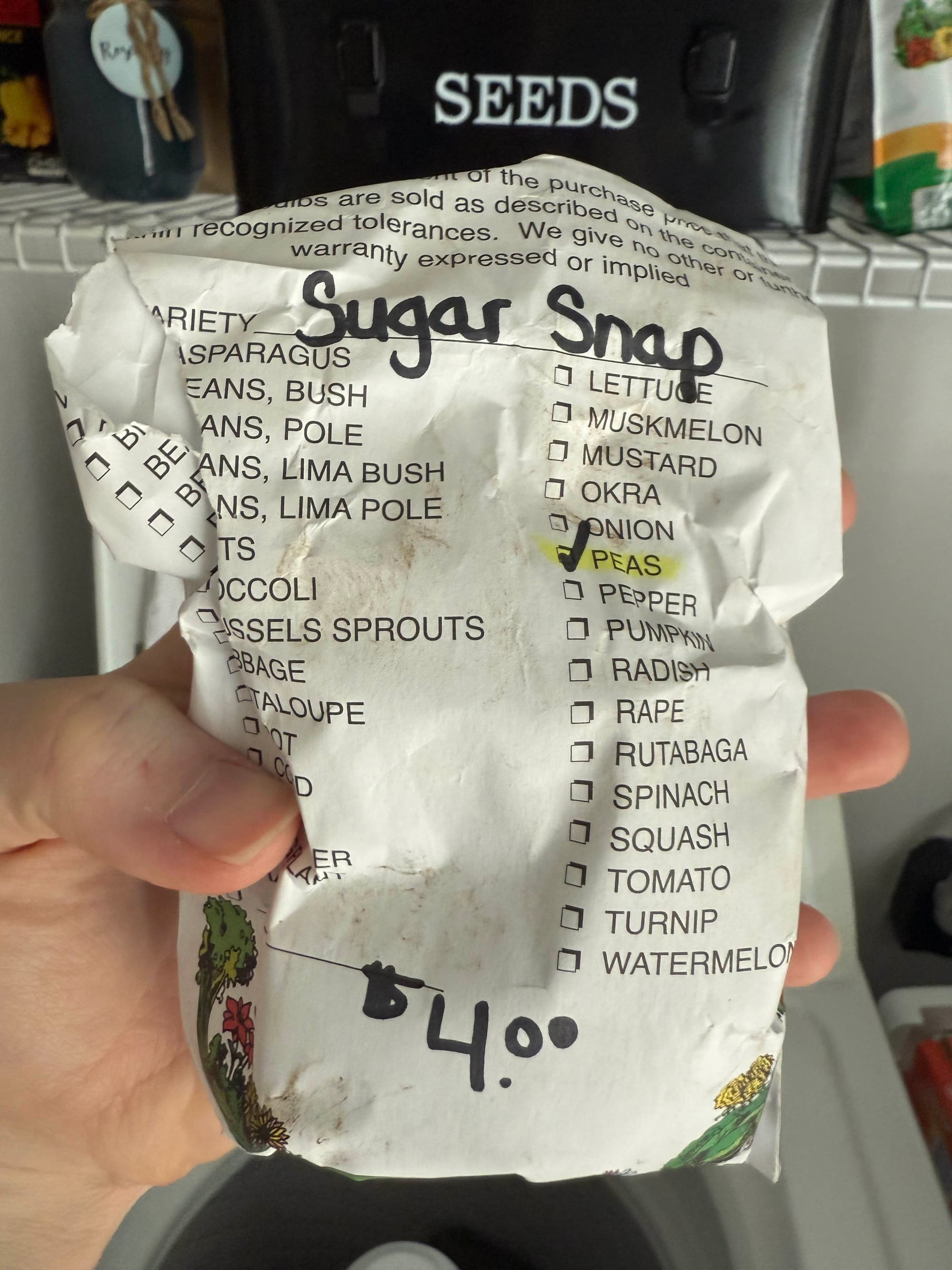 A seed back with "Sugar Snap Peas" labeled on the front and a price of $4.00.