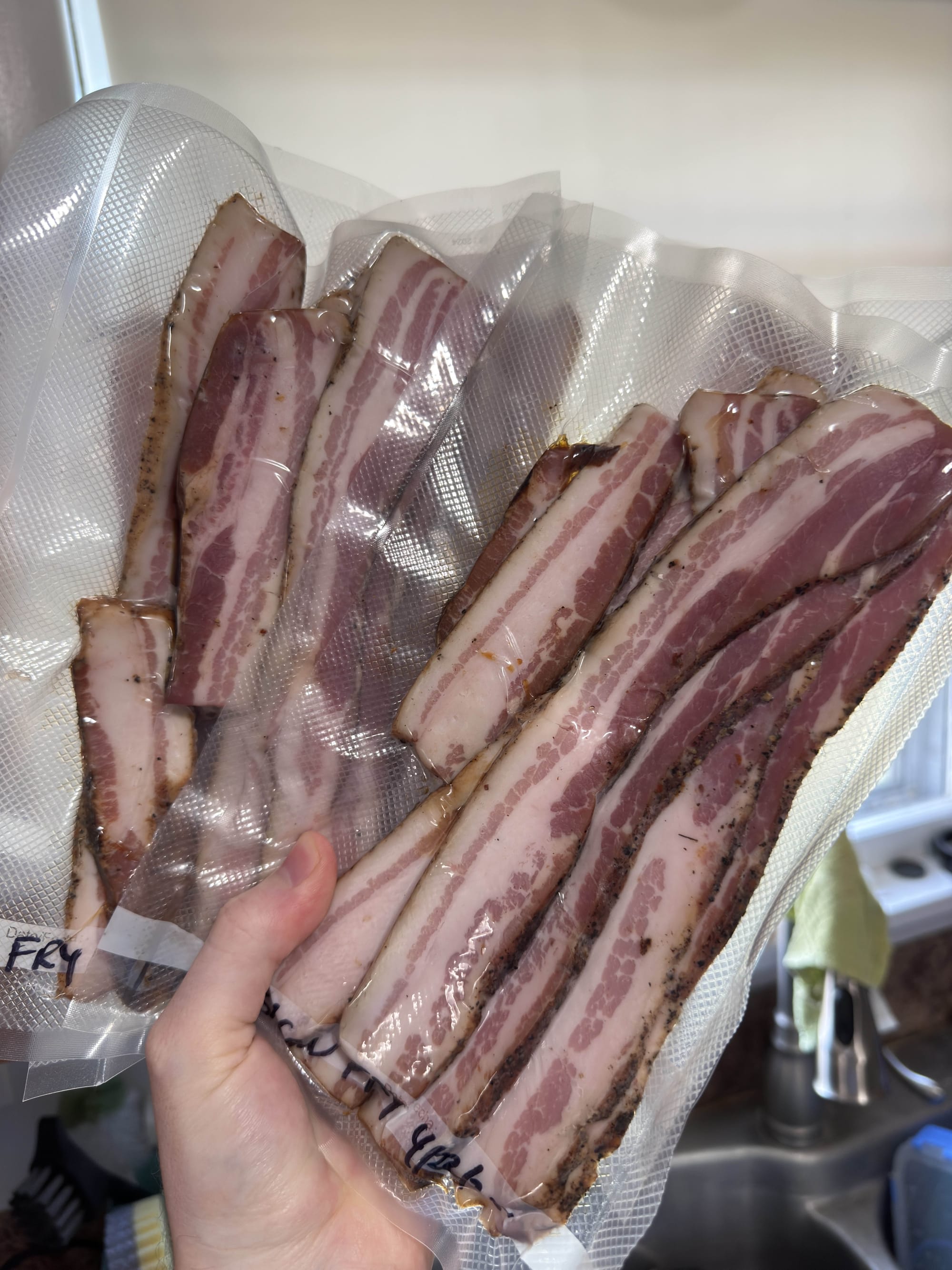Many slices of bacon sealed up in vacuum sealer bags, ready to freeze.